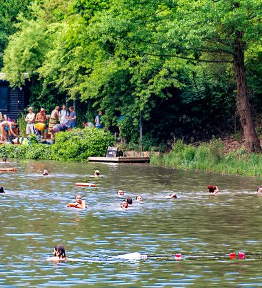 The fair is at Hampstead Heath, people are picniking and swimming